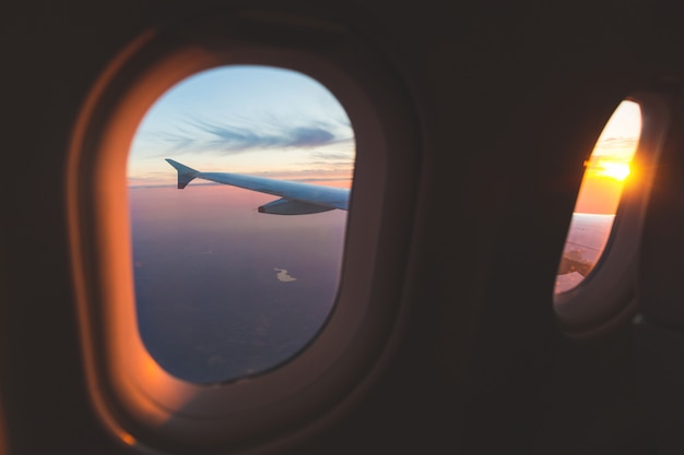 Coucher de soleil vue aérienne à travers la fenêtre de l&#39;avion au-dessus des ailes