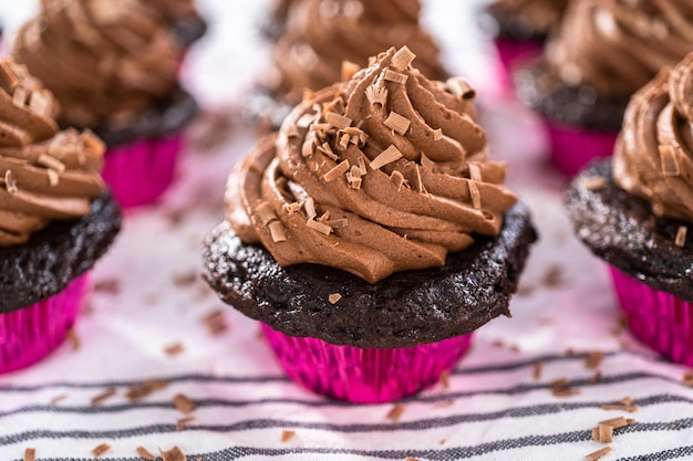 Couler un glaçage de ganache au chocolat sur des cupcakes au chocolat.