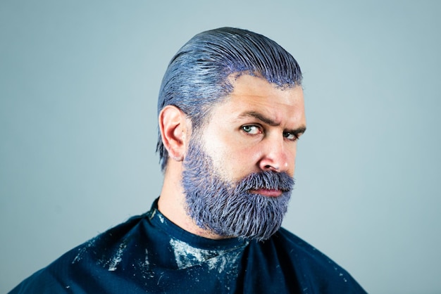 Couleur des cheveux des hommes. Mec barbu dans la barbe et la moustache de cheveux colorés de salon de coiffure. Gros plan du visage masculin sérieux.