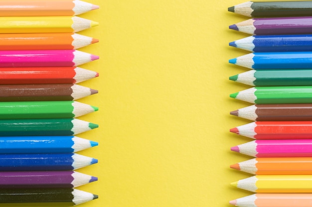 Photo couleur de crayons sur fond de papier jaune.