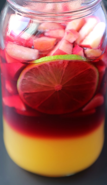 Couleur vive de la sangria au vin rouge maison dans une bouteille d'herbe avant le mélange