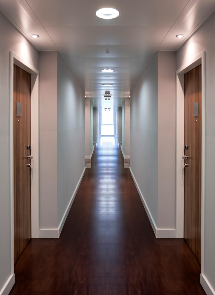Photo couloir de bureau d'hôtel vide et lumineux avec parquet couloir avec porte fermée en bois