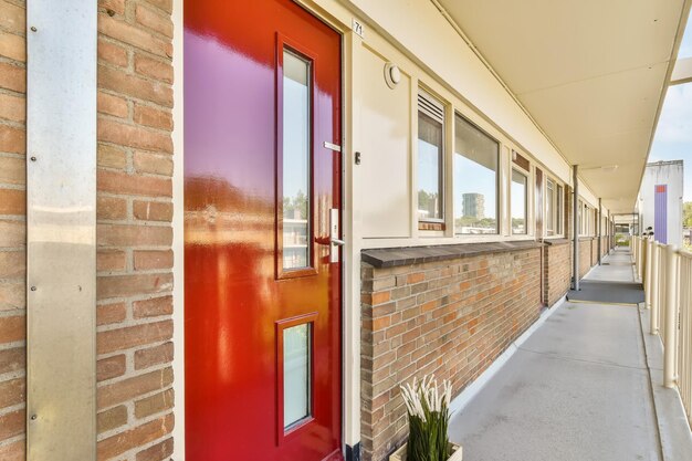 un couloir vide avec une porte rouge dans un bâtiment