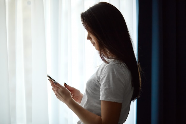 Coup de côté d'une jeune femme aux cheveux noirs en t-shirt blanc