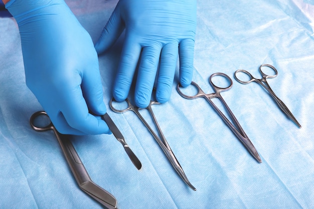 Coup de détail d&#39;instruments de chirurgie stérilisés avec une main saisissant un outil