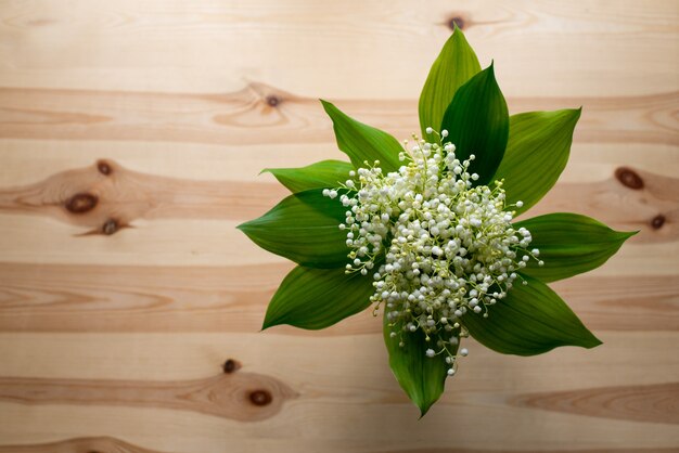 Coup de haut en bas du beau bouquet de muguet sur la vieille table en bois