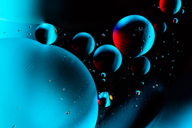 Coup de macro de bulles d'huile avec de l'eau sur coloré.