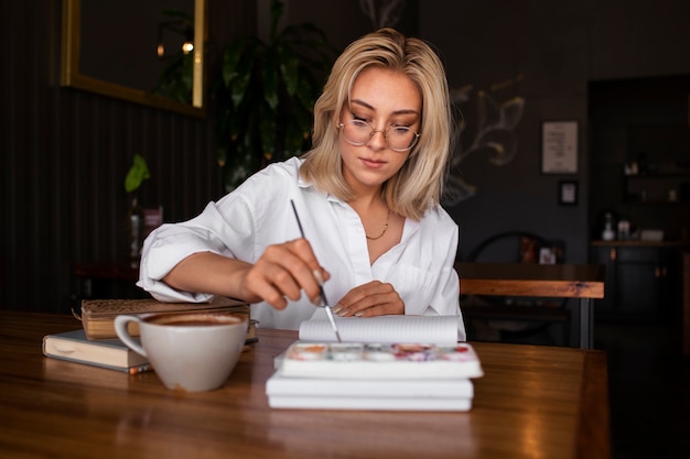 Photo coup moyen femme journalisant avec de la peinture