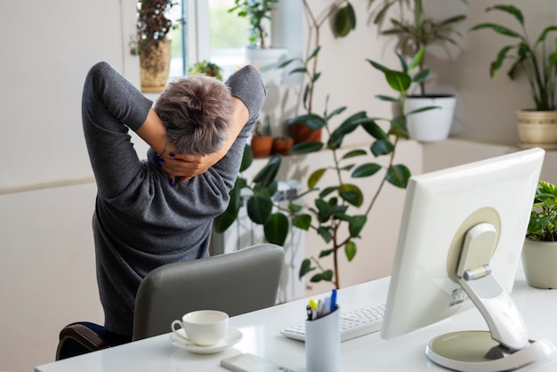 Coup moyen femme qui s'étend au bureau