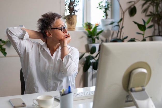 Coup moyen femme qui s'étend au bureau