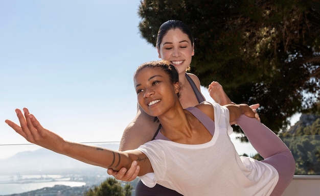 Photo coup moyen des femmes heureuses faisant du yoga