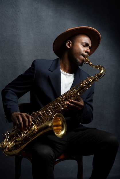 Photo coup moyen homme jouant du saxophone à l'intérieur