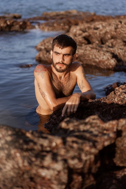 Photo coup moyen homme à la poitrine velue au bord de la mer