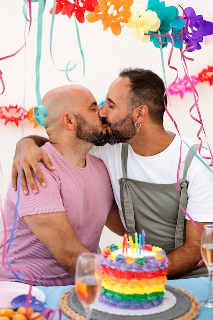 Coup moyen hommes s'embrassant à la fête d'anniversaire