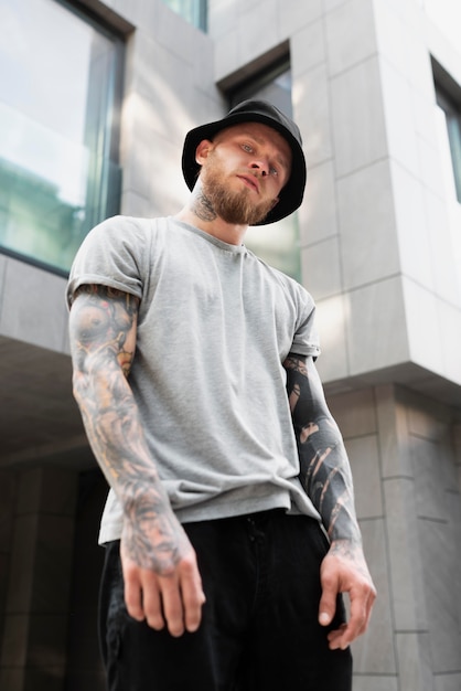 Photo coup moyen jeune homme avec des tatouages sur les bras