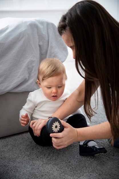 Photo coup moyen mère aidant un enfant à mettre des chaussures