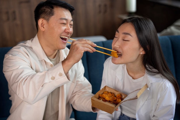 Photo coup moyen de personnes mangeant de la nourriture asiatique