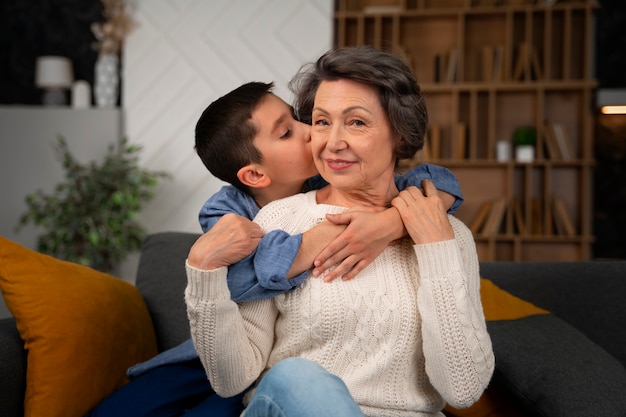 Photo coup moyen petit-fils embrassant grand-mère