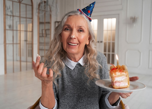 Coup moyen vieille femme tenant un gâteau