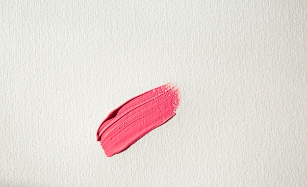 coup de pinceau de peinture rose avec des paillettes sur un frottis rose de papier aquarelle blanc