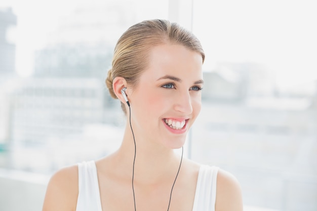 Coup de tête de femme sportive souriante, écouter de la musique