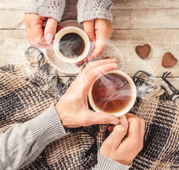 Coupe boisson pour le petit déjeuner entre les mains des amoureux. Mise au point sélective.