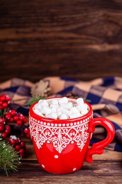 Coupe avec cacao et guimauves au fond en bois de décorations de Noël confortable