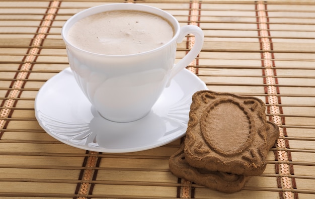 Coupe avec capucino et biscuit