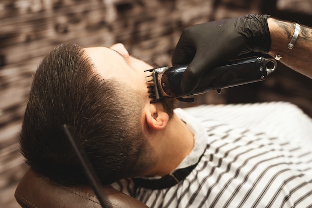 Coupe de cheveux en barbier, Barber coupe les cheveux sur la tête du client.