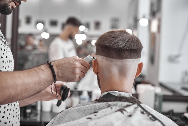 Coupe de cheveux et coiffure en salon de coiffure. Soin des cheveux. Style et style de vie des hommes. Barber apporte une coupe de cheveux et une barbe à son client.