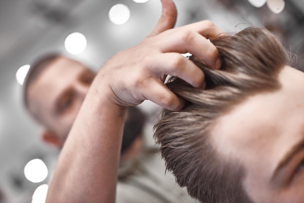 Coupe de cheveux et coiffure en salon de coiffure. Soin des cheveux. Style et style de vie des hommes. Barber apporte une coupe de cheveux et une barbe à son client.