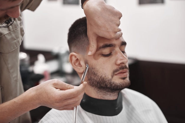 Coupe de cheveux et coiffure en salon de coiffure. Soin des cheveux. Style et style de vie des hommes. Barber apporte une coupe de cheveux et une barbe à son client.