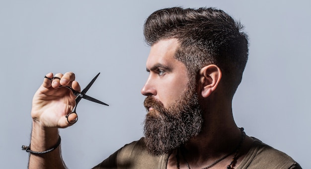 Photo coupe de cheveux de l'homme au salon de coiffure. ciseaux de coiffeur, salon de coiffure. ciseaux de coiffeur.