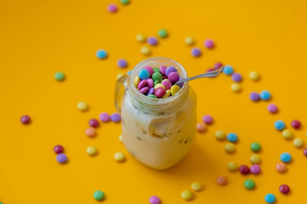 Coupe de crème glacée avec des bonbons à la dragée sur jaune