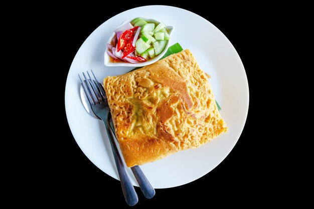 Photo coupe de crêpe croustillante thaïlandaise kanom buang omelette croustillante farcie vietnamienne avec des tranches de concombre et de piment vinaigre acide sur noir isolé