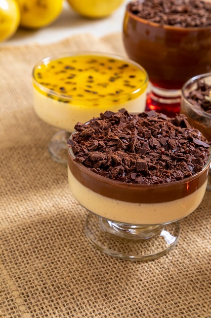 Coupe de dessert avec mousse au chocolat au lait et copeaux de chocolat blanc, mousse à la ganache et mousse aux fruits de la passion.