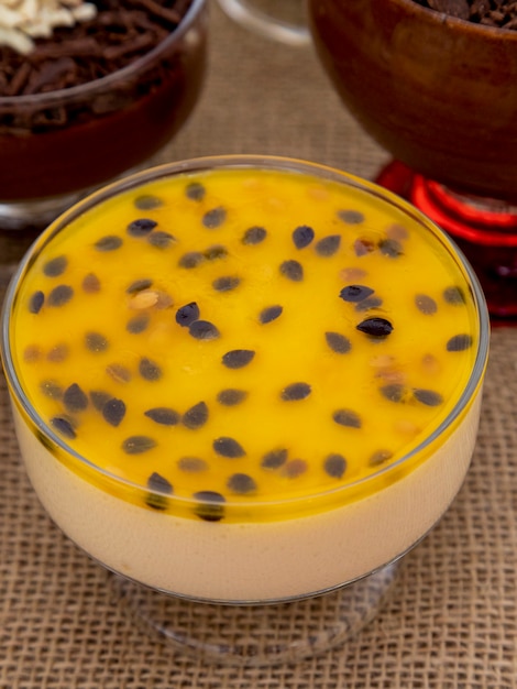 Coupe de dessert avec mousse au chocolat au lait et copeaux de chocolat blanc, mousse ganache et mousse aux fruits de la passion.