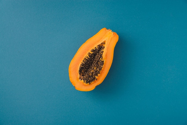 Coupe-fruits de papaye unique sur la moitié sur fond bleu