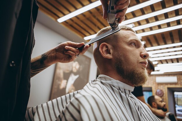 Photo coupe en gros plan avec une tondeuse et un flux de travail de peigne dans un salon de coiffure moderne et élégant