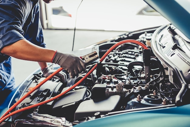 Photo coupe médiane d'un homme travaillant sur une voiture dans un garage