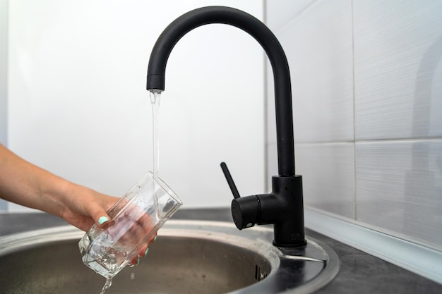 Photo coupe médiane d'une personne versant de l'eau dans un verre