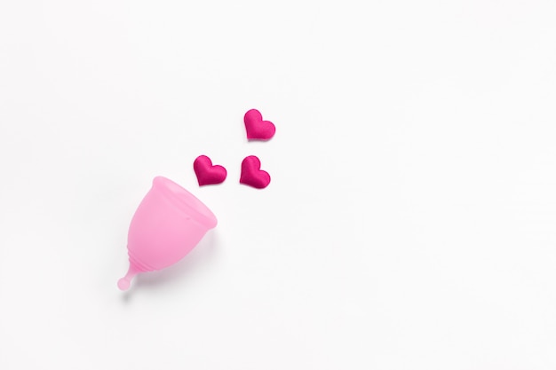 Coupe menstruelle rose sur fond blanc avec un cœur cramoisi