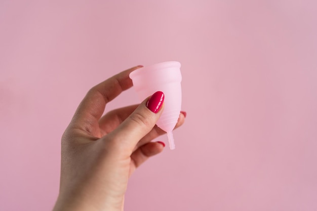 Coupe menstruelle en silicone Santé des femmes et hygiène alternative Coupe avec fleur sur fond rose Alternatives zéro déchet