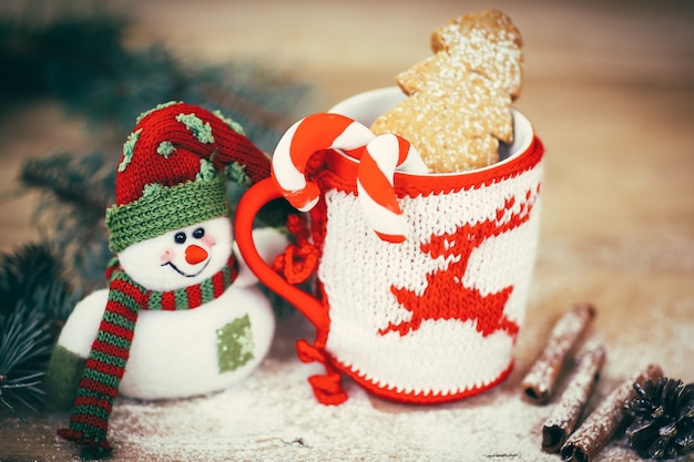 Coupe de Noël et un bonhomme de neige jouet sur fond en bois. le concept de Noël