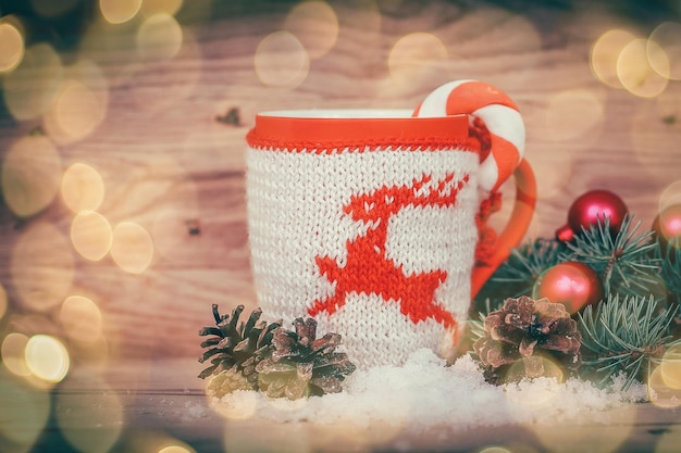 Coupe de Noël et branche de sapin sur fond de bois