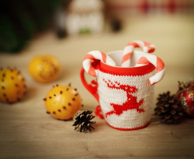 Coupe de Noël et oranges sur fond de bois flou