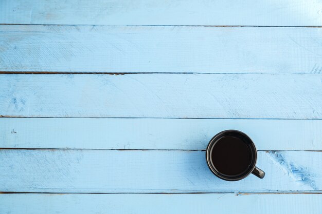 Coupe noire avec boisson sur bois bleu