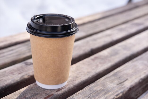 Photo coupe en papier avec du café sur fond en bois avec de l'espace pour le design