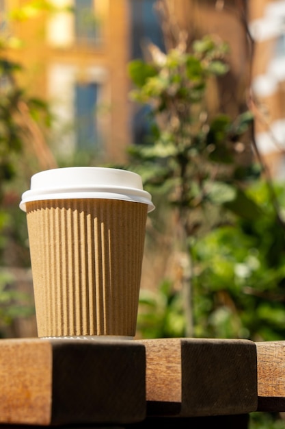 Photo coupe en papier recyclé écologique avec du café ou du thé sur papier kraft sur table en bois petit déjeuner dans la rue