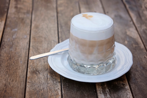 Coupe en verre de café au lait sur la table en bois